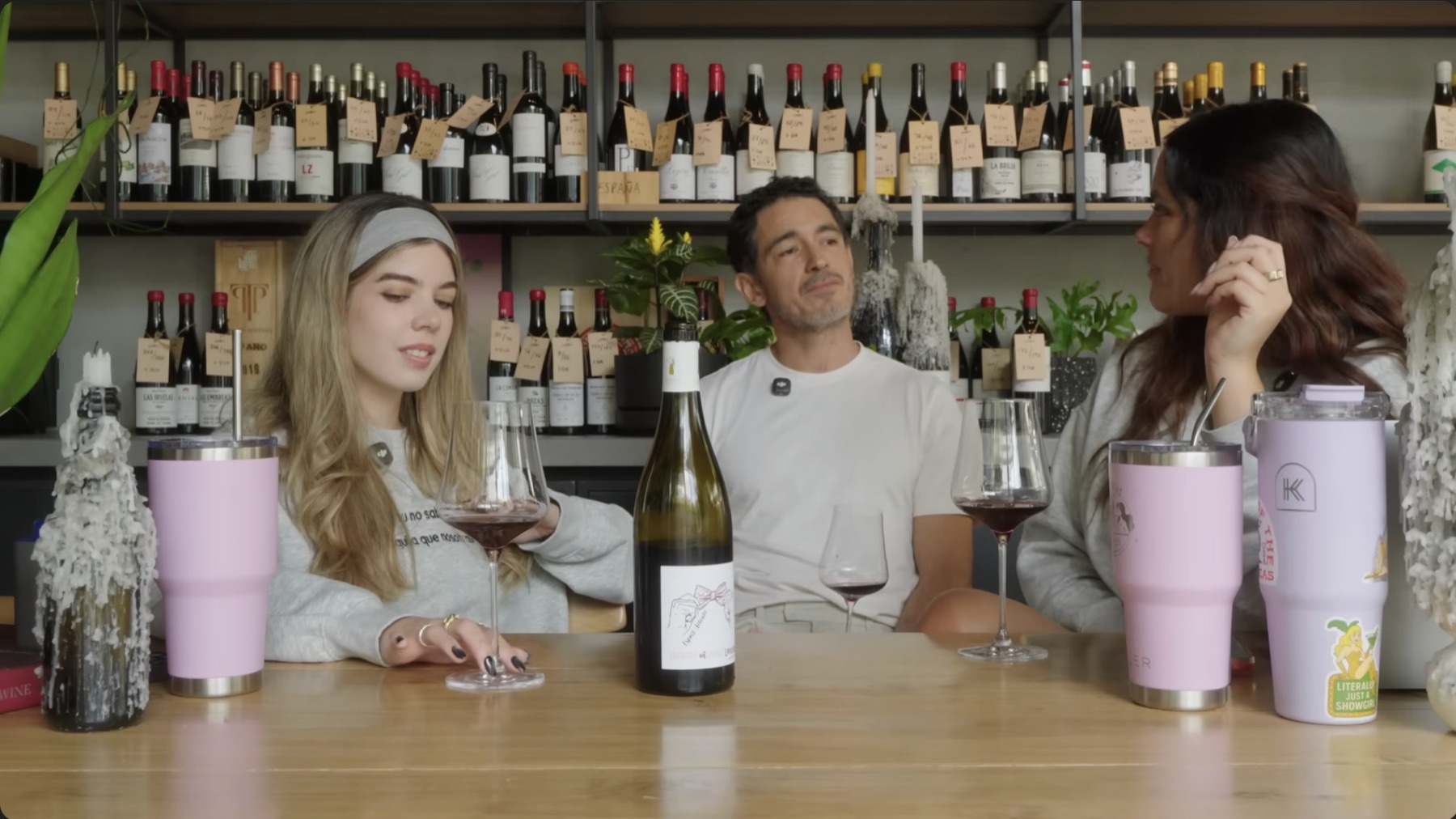 Tres personas conversan con copas de vino durante un episodio de Las Chicas de las Bebidas
